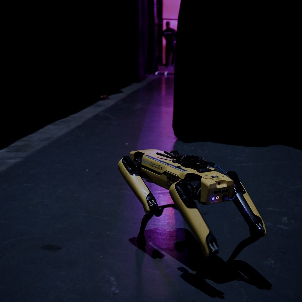 Quadruped robot moving through a dark corridor